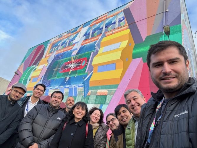 Integrantes de SAPHIR frente al mural del experimento CMS, CERN.
